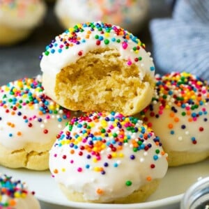 A plate of Italian cookies with a bite taken out of one.