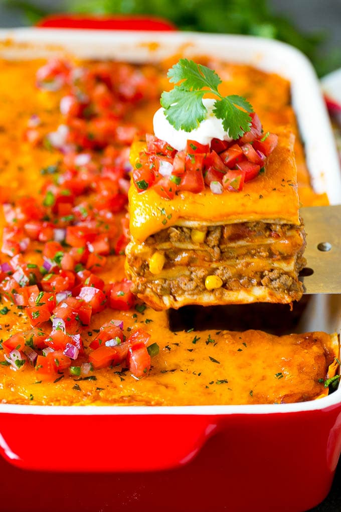Mexican Lasagna Recipe | Mexican Casserole #mexican #lasagna #groundbeef #beans #dinner #cheese #edsug A spatula serving up a portion of Mexican lasagna.