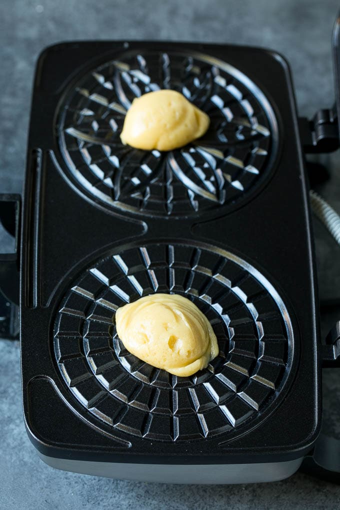 Pizzelle Cookies Recipe #cookies #baking #dessert #christmas #edsug Dollops of dough in a cookie iron.