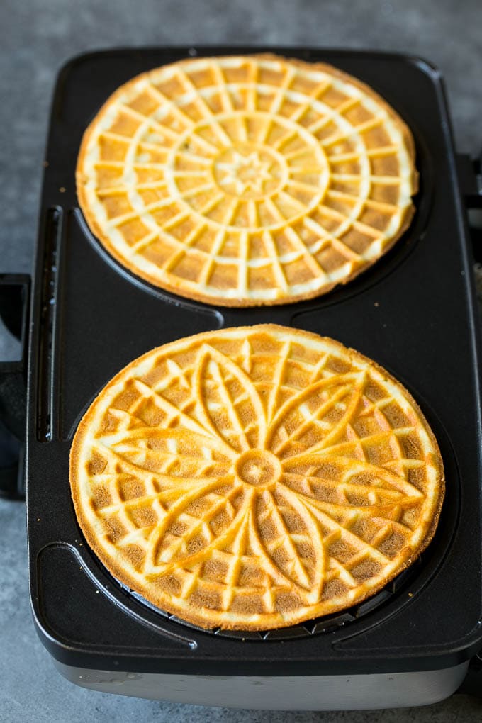 Pizzelle Cookies Recipe #cookies #baking #dessert #christmas #edsug Baked cookies inside a pizzelle iron.