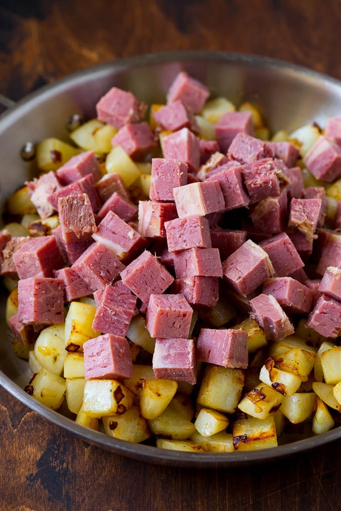 Corned Beef Hash Recipe #hash #cornedbeef #stpatricksday #breakfast #brunch #potatoes #edsug Cubed corn beef on top of cooked potatoes.