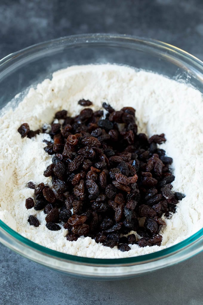 Irish Soda Bread Recipe #bread #baking #stpatricksday #sidedish #edsug Flour, sugar, butter, baking powder and raisins in a mixing bowl.