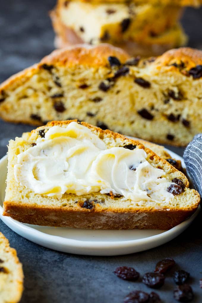 Irish Soda Bread Recipe #bread #baking #stpatricksday #sidedish #edsug A slice of Irish soda bread with butter spread on it.