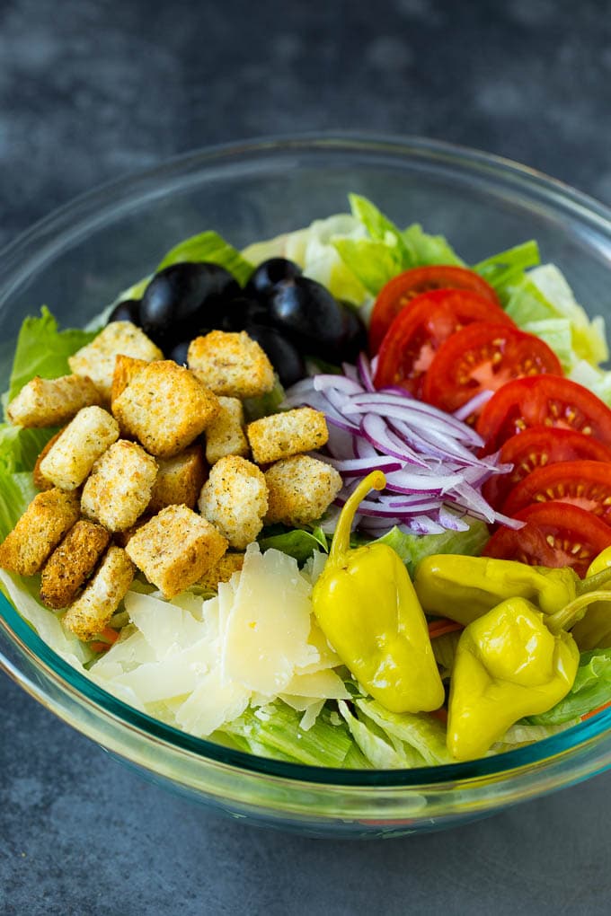 Olive Garden Salad Recipe | Italian Salad #salad #lettuce #olives #sidedish #dinner #edsug Lettuce, vegetables, olives and croutons in a bowl.
