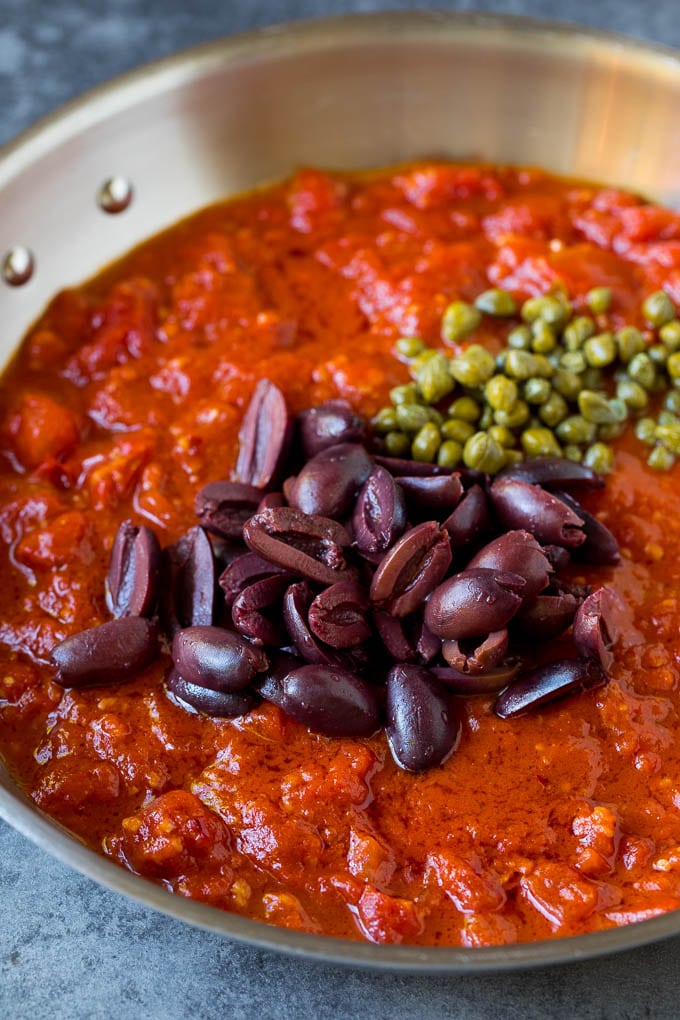 Pasta Puttanesca Recipe #pasta #tomatoes #olives #italianfood #dinner #edsug Tomato sauce with olives and capers on top.