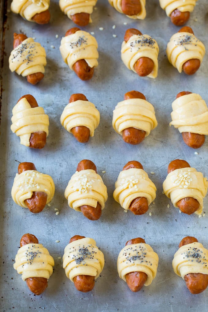 Pigs in a Blanket Recipe #hotdogs #appetizer #snack #comfortfood #edsug Mini hot dogs wrapped in crescent dough and topped with seeds.