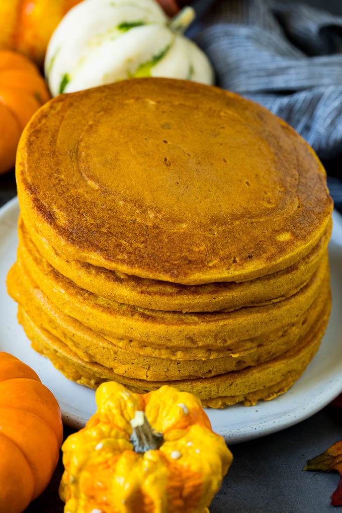 These pumpkin pancakes are light and fluffy buttermilk hotcakes flavored with pumpkin puree and spices. A stack of hot cakes surrounded by fall decorations.