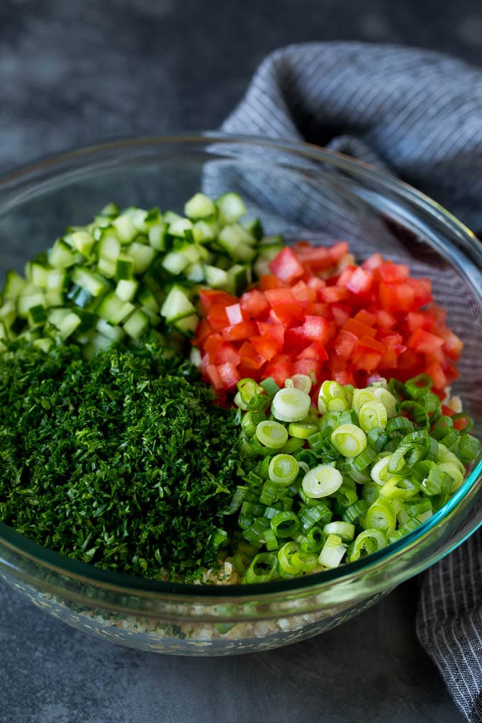 Tabbouleh Salad | Tabouli #salad #wheat #tomatoes #cucumber #healthy #sidedish #dinner #edsug A bowl of bulgur topped with herbs, tomatoes and cucumber.