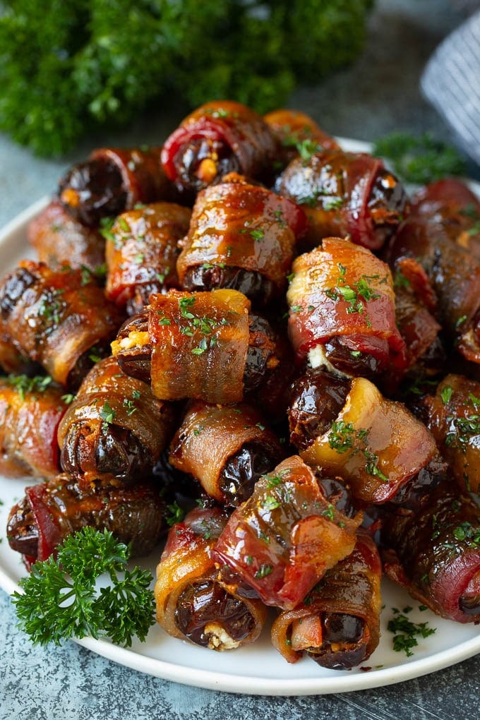 Bacon Wrapped Dates #appetizer #bacon #dates #cheese #edsug A plate of bacon wrapped dates stuffed with goat cheese.