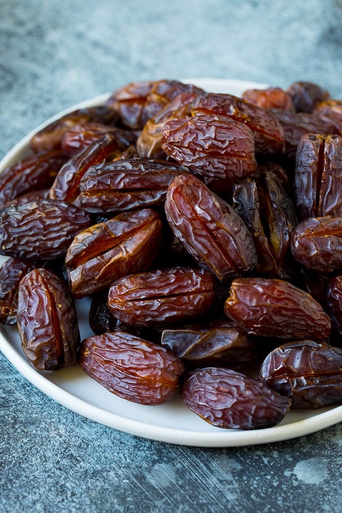 Bacon Wrapped Dates #appetizer #bacon #dates #cheese #edsug Dates split open on a plate.