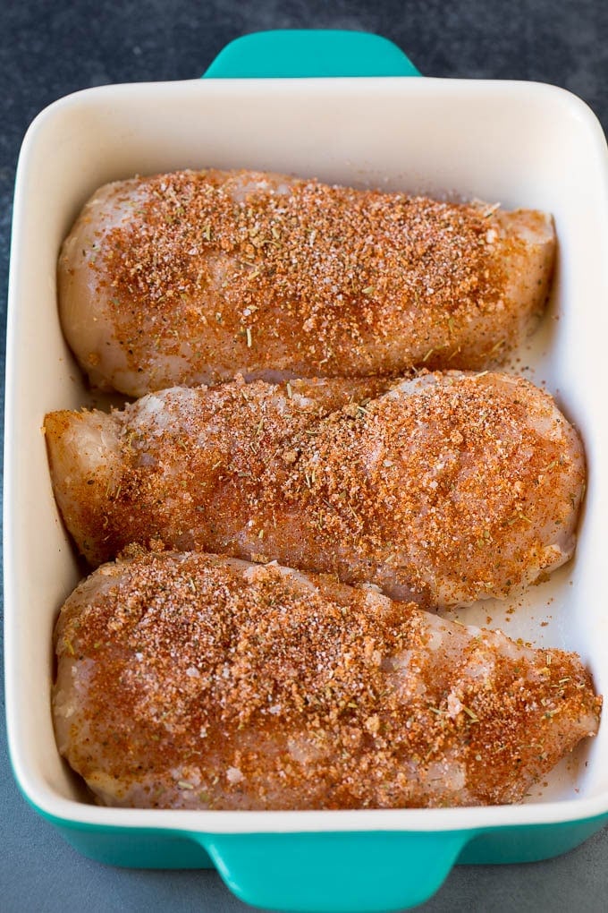 Baked Chicken Breast Recipe #chicken #dinner #edsug Chicken coated in seasonings in a baking dish.