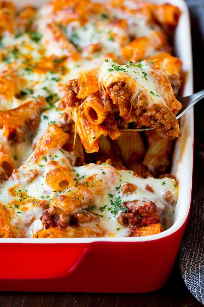 Baked Rigatoni Pasta #pasta #dinner #italianfood #groundbeef #edsug #casserole A spoon serving up a portion of baked rigatoni pasta.