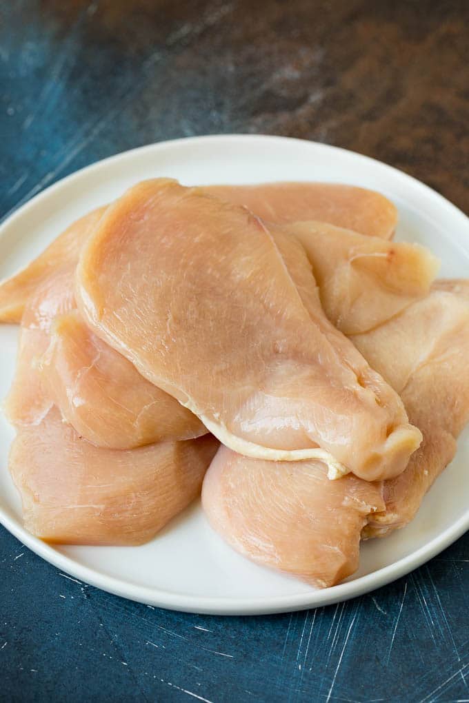 Chicken Francese Recipe #chicken #lemon #dinner #edsug Thin cut chicken breasts on a plate.