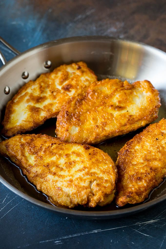 Chicken Francese Recipe #chicken #lemon #dinner #edsug Battered and pan fried chicken cutlets in a pan.
