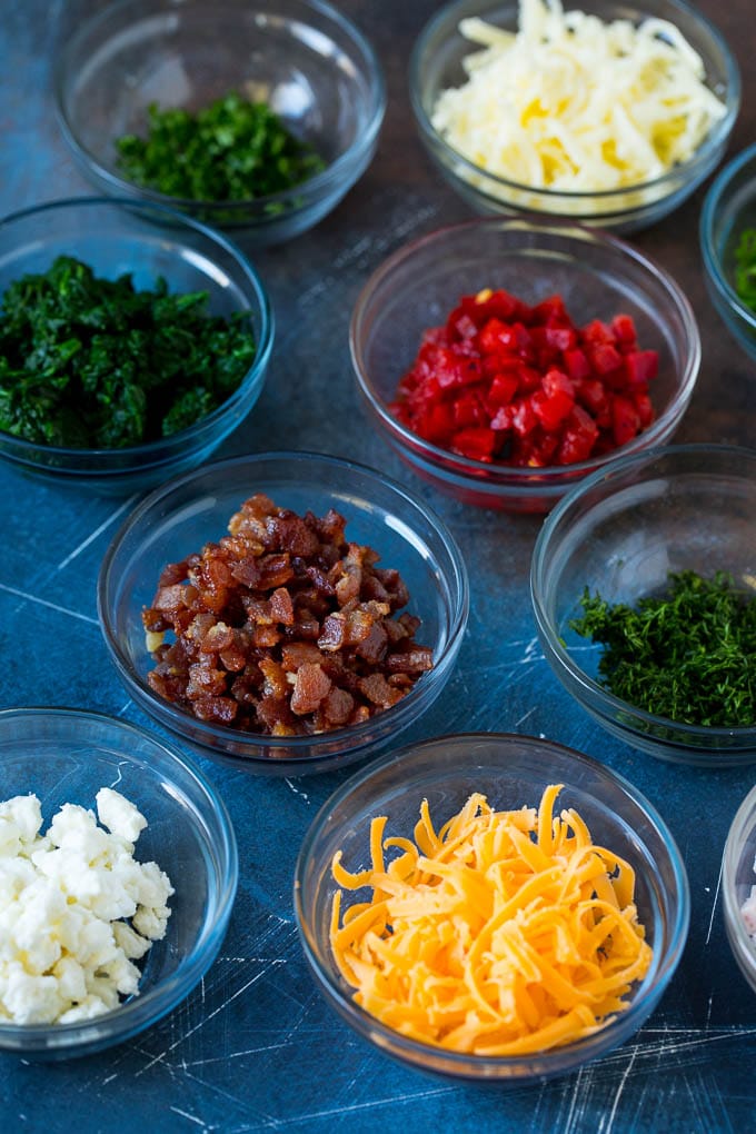 Mini Quiche Recipe #eggs #breakfast #brunch #appetizer #edsug Bowls of assorted flavorings for quiche.