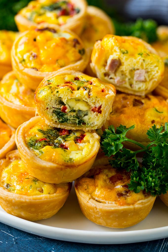 Mini Quiche Recipe #eggs #breakfast #brunch #appetizer #edsug A serving platter of mini quiche with some cut in half.
