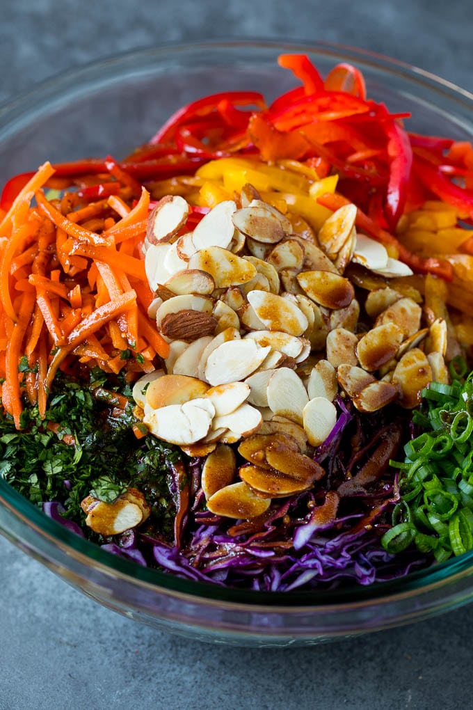 Asian Slaw Recipe #salad #slaw #sidedish #edsug Homemade dressing poured over Asian coleslaw.