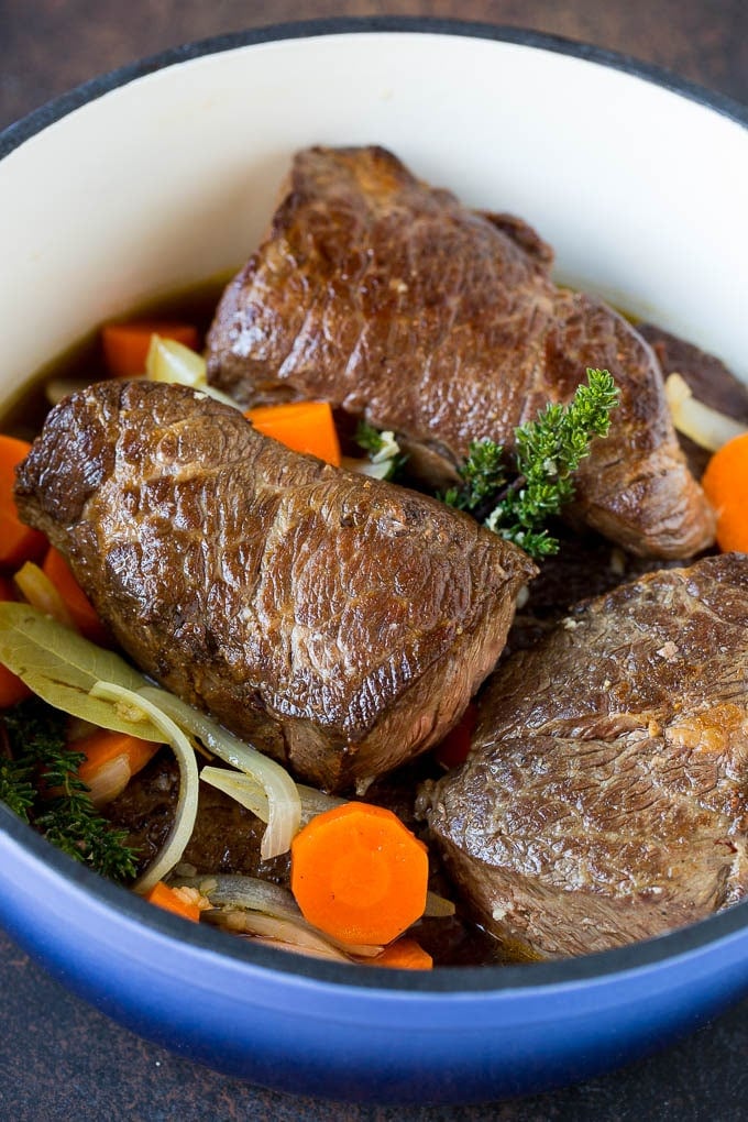 Short ribs with carrots and onions in a pot.