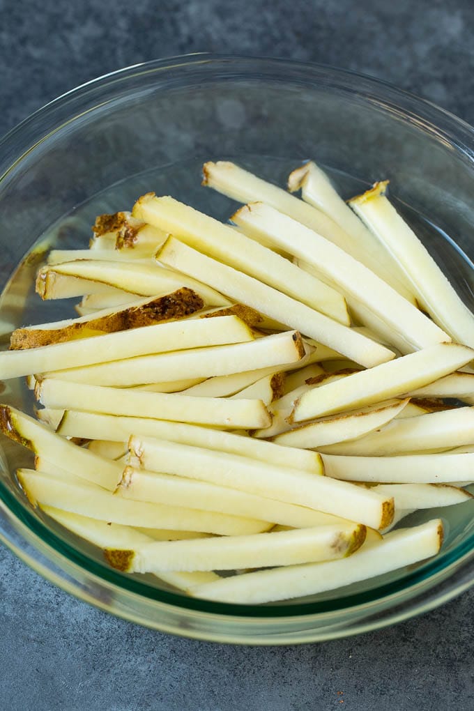 Homemade French Fries Recipe #potatoes #fries #dinner #edsug Sliced potato sticks in a bowl of water.