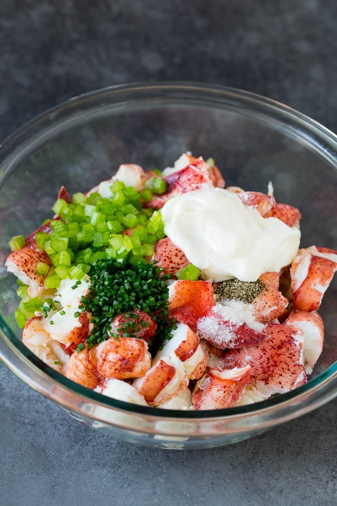 Lobster rolls stuffed with creamy lobster salad in a toasted bun. #lobster #edsug Lobster, chives, celery and mayonnaise in a bowl.
