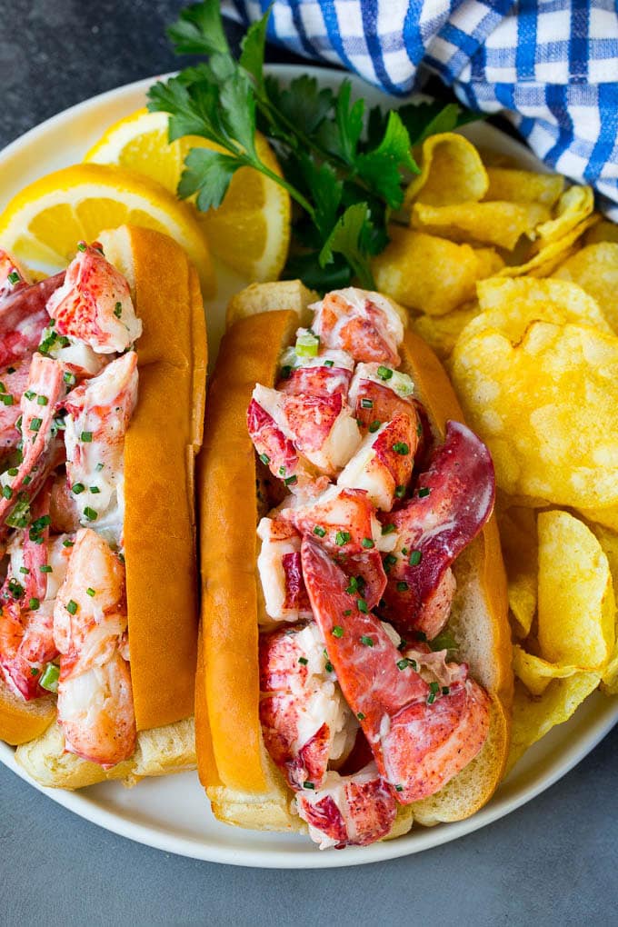 Lobster rolls stuffed with creamy lobster salad in a toasted bun. #lobster #edsug A lobster roll filled with a creamy seafood mixture and served with chips.