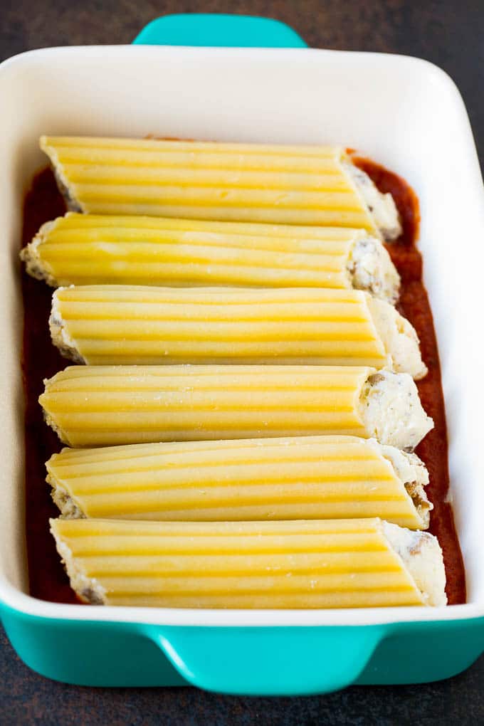 Baked Manicotti Recipe #pasta #cheese #dinner #edsug Pasta tubes stuffed with sausage and cheese in a baking dish.