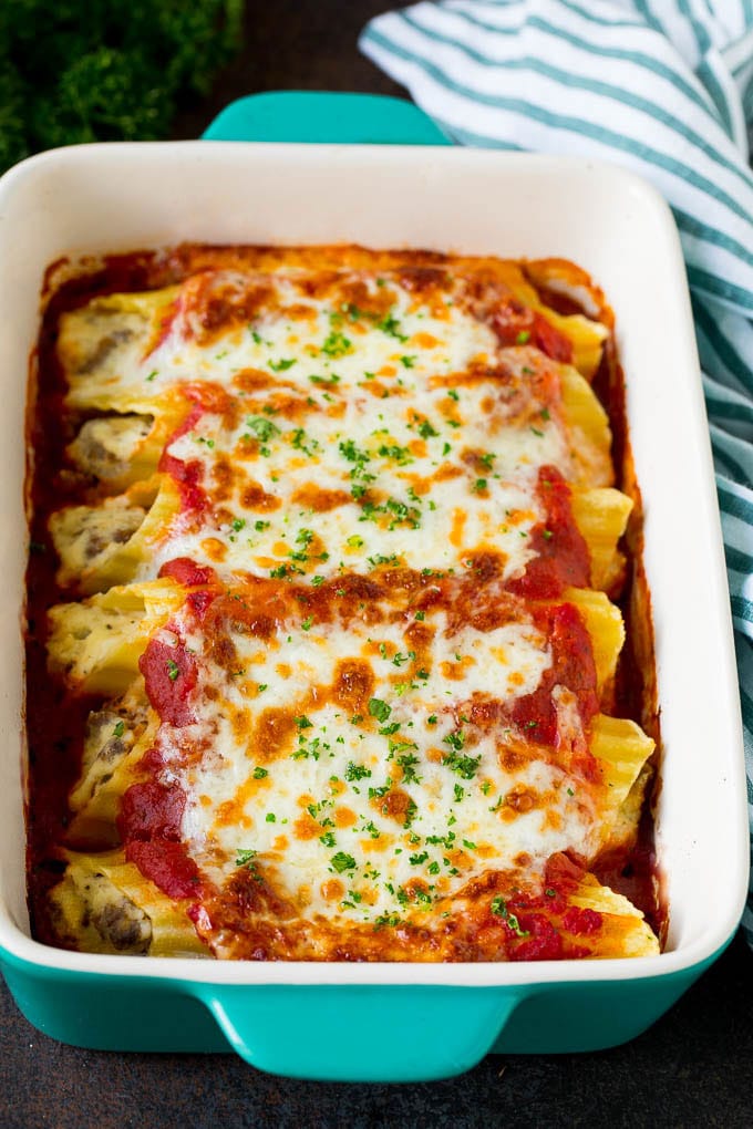 Baked Manicotti Recipe #pasta #cheese #dinner #edsug A dish of baked manicotti pasta topped with melted cheese and parsley.