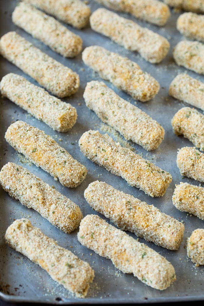 Mozzarella Sticks Recipe #cheese #appetizer #edsug Breaded cheese on a baking pan.
