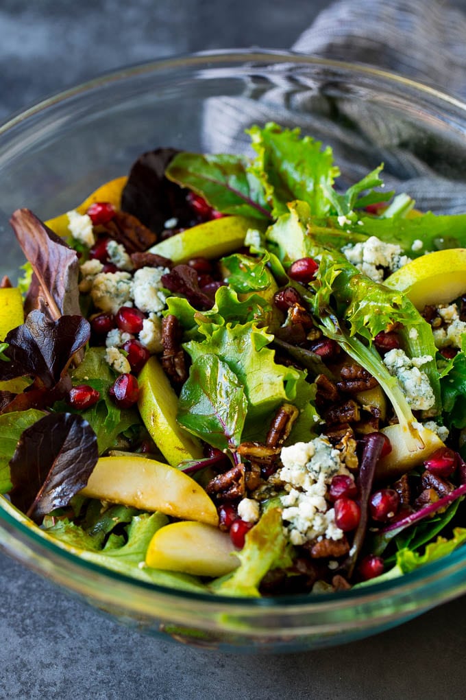 Pear Salad Recipe #salad #pears #fall #winter #dinner #edsug A bowl of pear salad with pomegranate, blue cheese and candied pecans.
