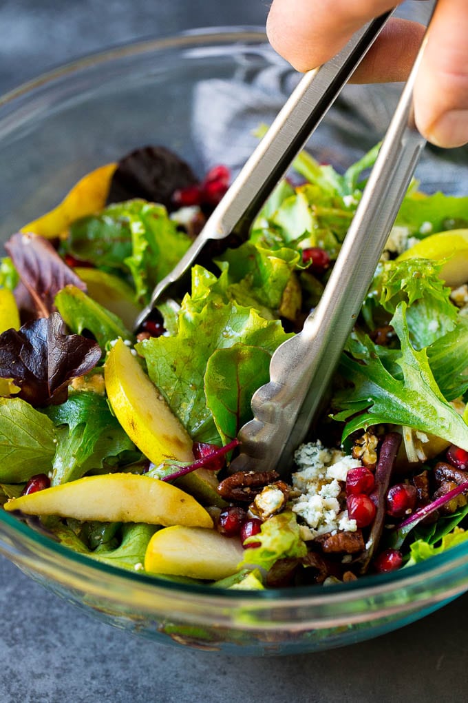 Pear Salad Recipe #salad #pears #fall #winter #dinner #edsug Tongs serving up a portion of pear salad.