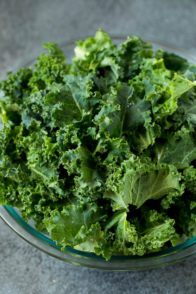 Sauteed kale flavored with olive oil and garlic, a quick and easy side dish! #kale #edsug Chopped kale in a mixing bowl.