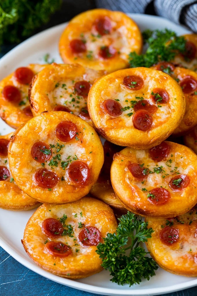 Mini pizzas topped with pepperoni are a fun and easy appetizer option. #pizza #edsug #appetizer Mini pizzas topped with melted cheese and pepperoni.