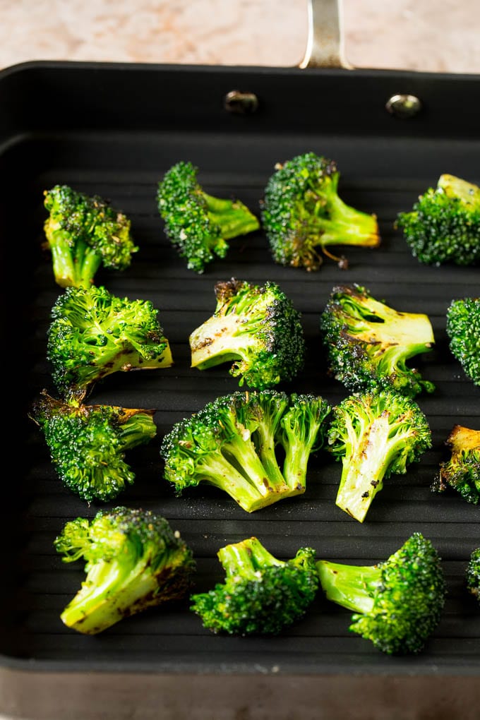 Grilled broccoli is packed with flavor and is a colorful and healthy side dish! #broccoli #edsug Broccoli florets on a grill pan.