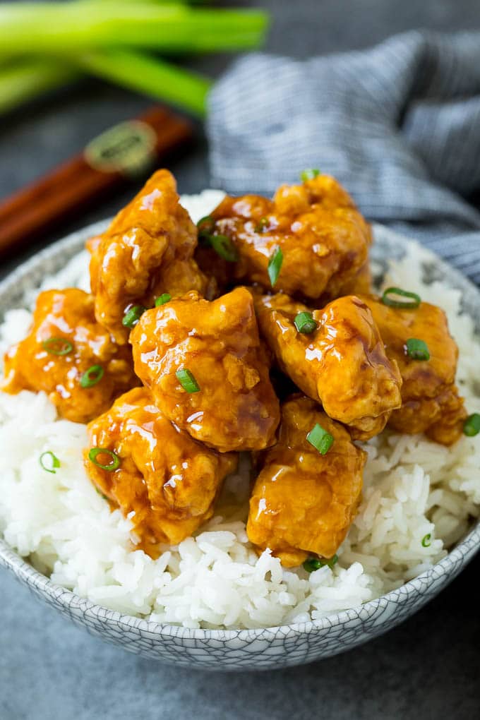 This honey chicken is crispy pieces of chicken breast that are fried to golden brown perfection, then tossed in a sweet and savory honey sauce. Honey chicken served over a bowl of steamed rice.