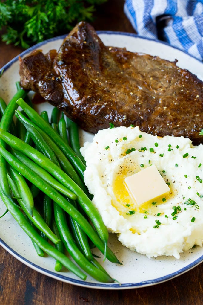 These cream cheese mashed potatoes are boiled potatoes blended with butter, milk, cream cheese and seasonings to make a rich and creamy side dish. Cream cheese mashed potatoes served with steak and green beans.