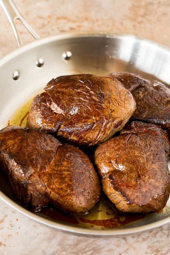 This Steak Diane recipe is beef tenderloin medallions that are seared and coated in a savory mushroom sauce. Seared steak in a pan.