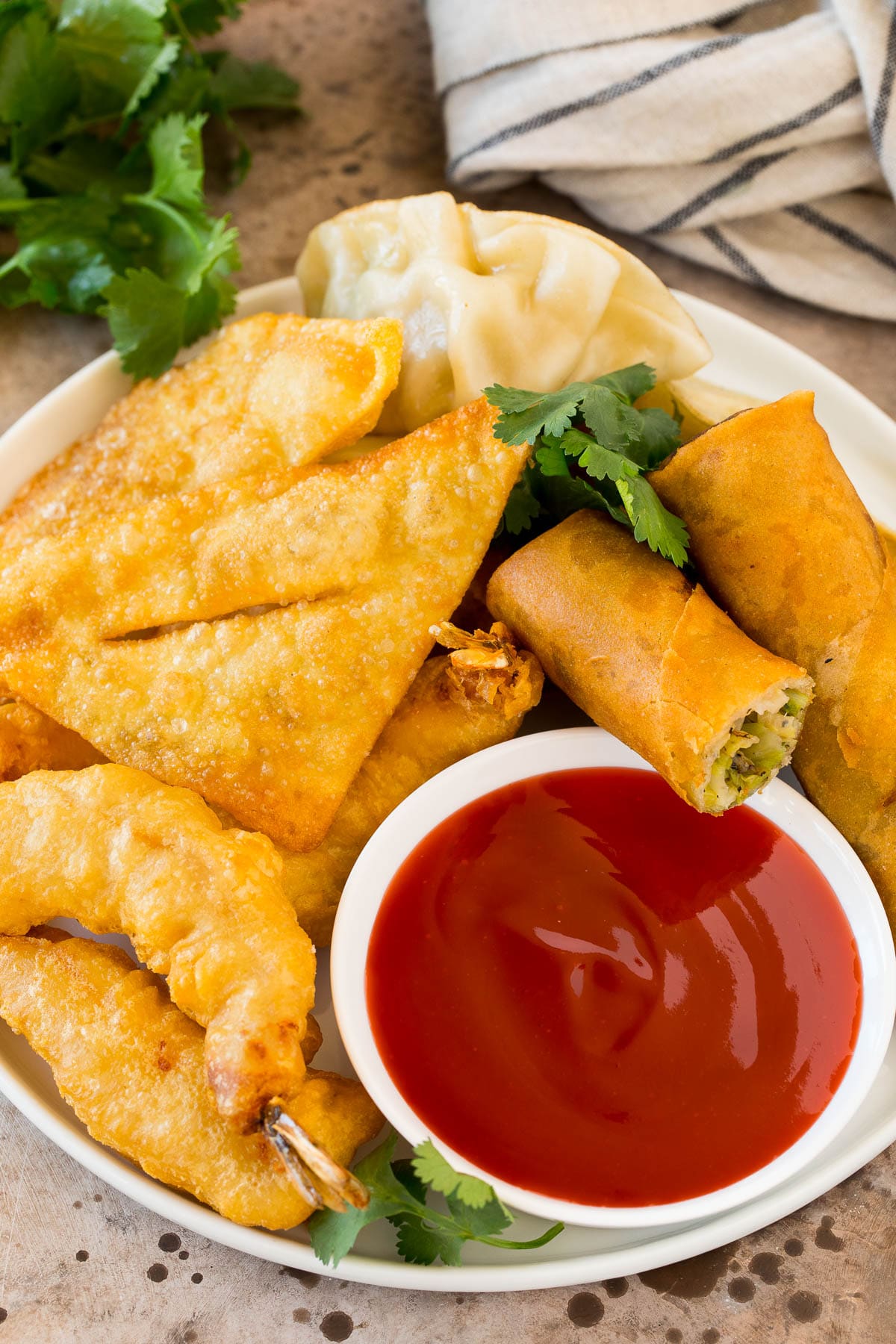 This sweet and sour sauce is a homemade version of the classic Asian sauce that takes just minutes to make and uses common pantry ingredients. A bowl of sweet and sour sauce served with egg rolls, shrimp and wontons.