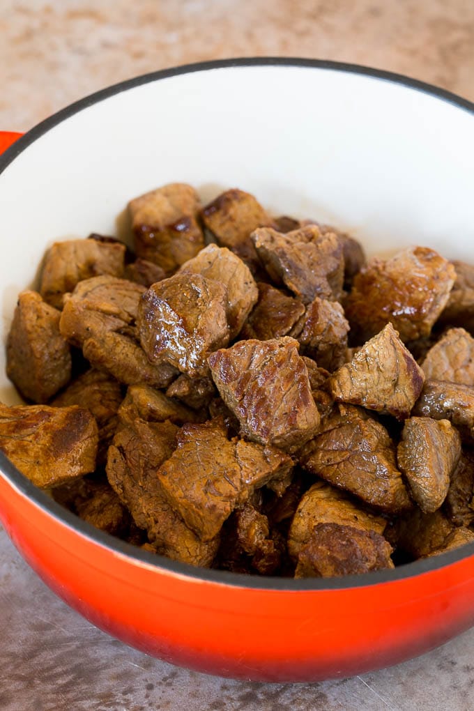 This Mexican style carne guisada is beef that is stewed with tomatoes, peppers and spices until it becomes tender and flavorful. Seared beef chunks in a pot.