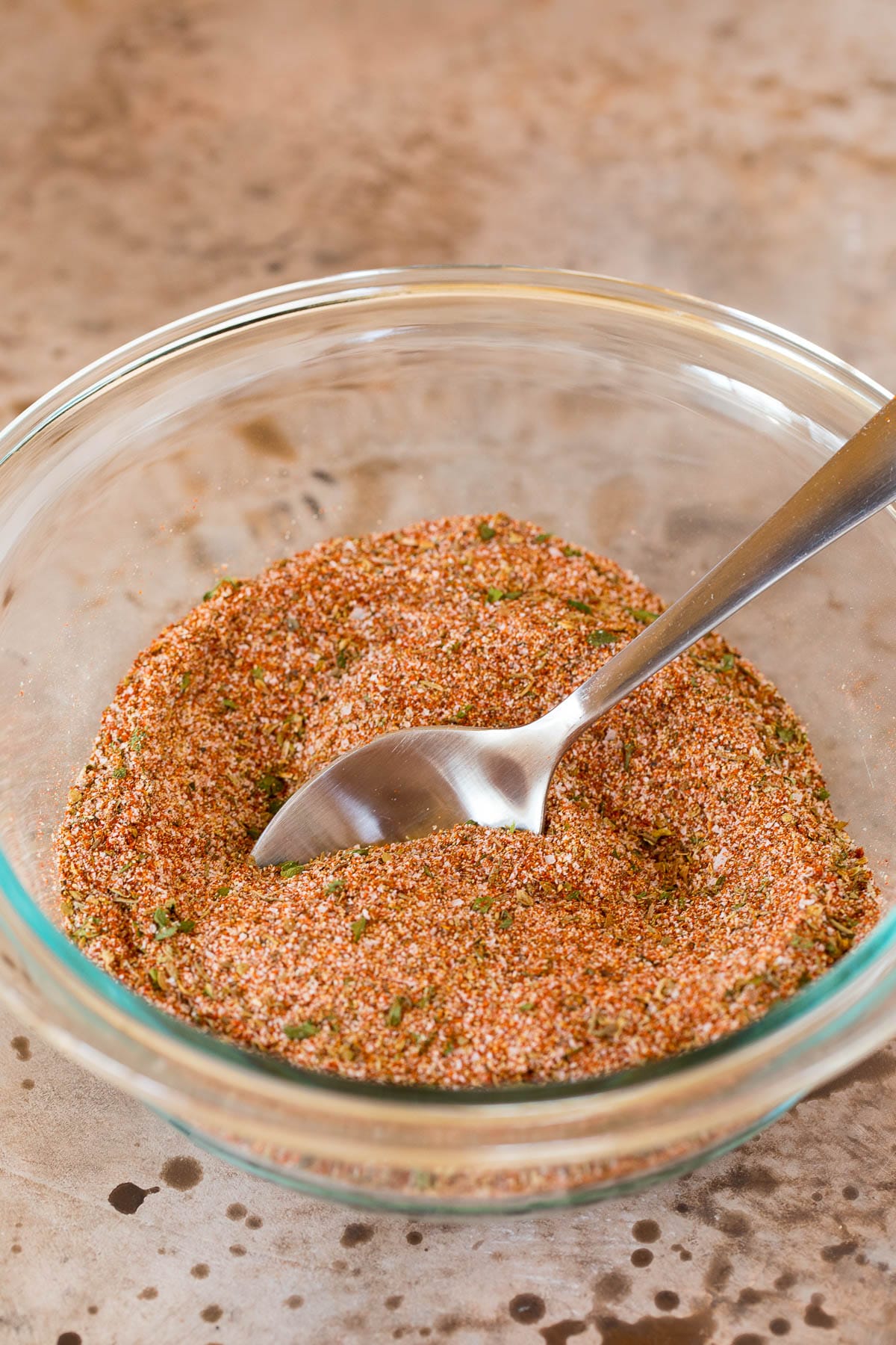 A bowl of seasoning blend with a spoon in it.