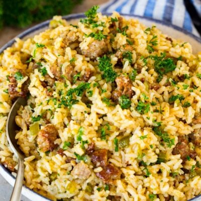 A bowl of dirty rice with a serving spoon in it.