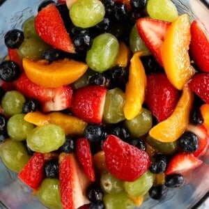 An image of various fruit in a bowl with peaches.