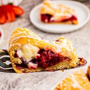 An image of a slice of a strawberry cheesecake crescent ring.