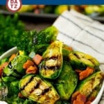 A bowl of balsamic brussels sprouts which are roasted and topped with crispy bacon, and drizzled with a sweet balsamic glaze.