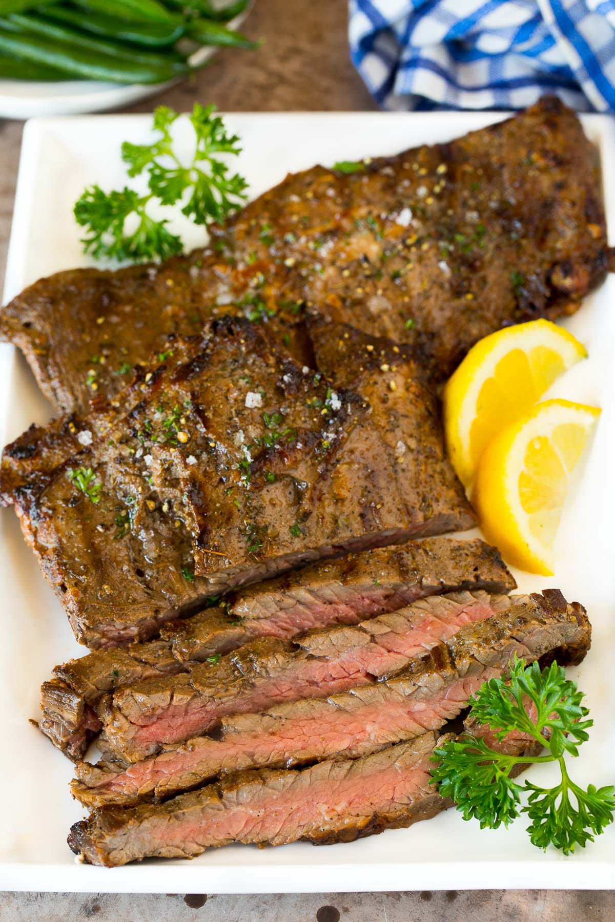 Steak coated in skirt steak marinade, grilled and sliced on a platter.