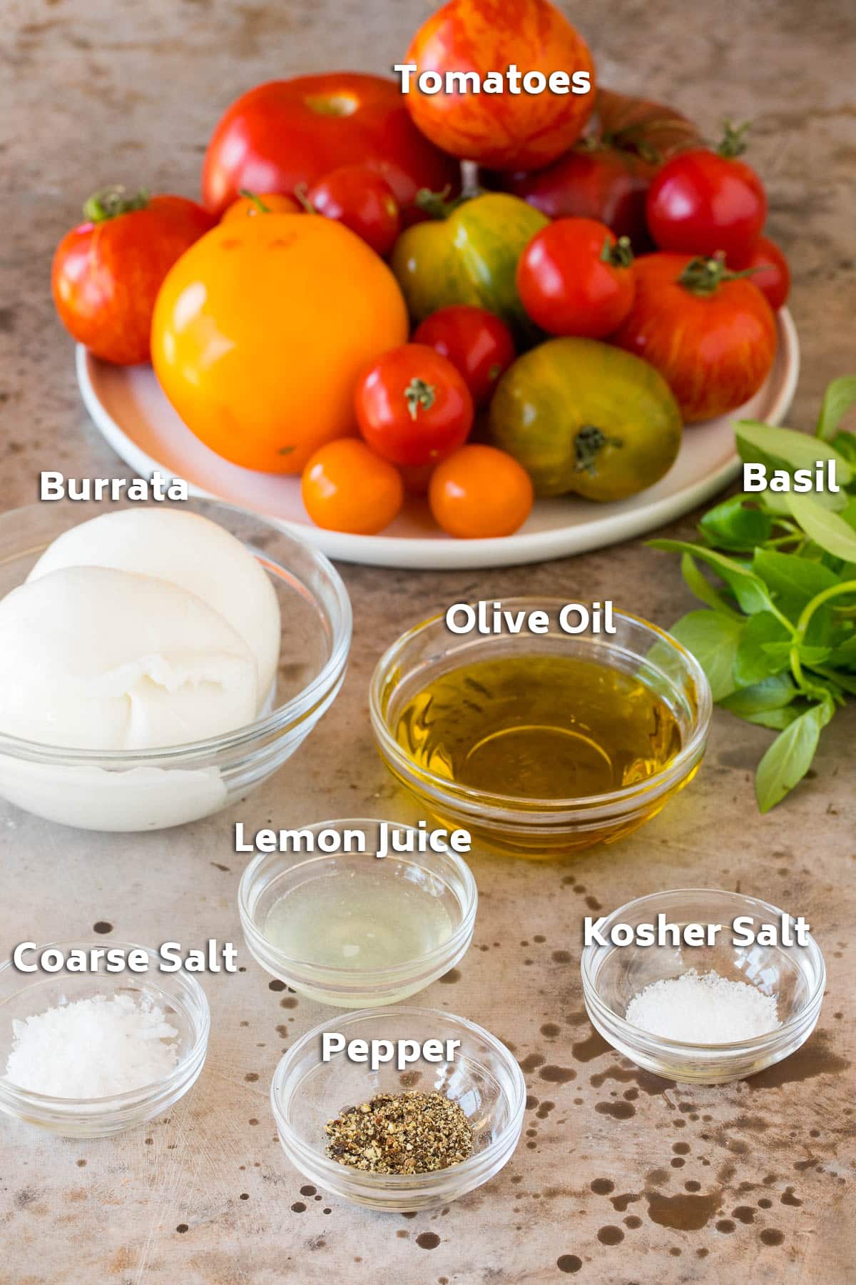 Bowls of ingredients including tomatoes, olive oil, burrata cheese and seasonings.