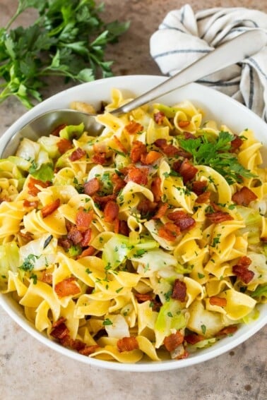 A bowl of haluski topped with bacon and parsley.