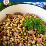 A pot of Hoppin' John which is ham and black eyed peas garnished with parsley.
