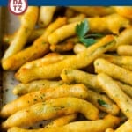 Fried green beans on a baking sheet garnished with parsley.
