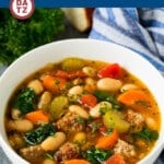 A bowl of delicious Tuscan white bean soup garnished with parsley and served with fresh bread.