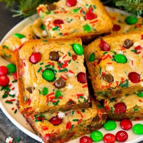 Christmas cookie bars on a plate with sprinkles and M&M candies as garnish.